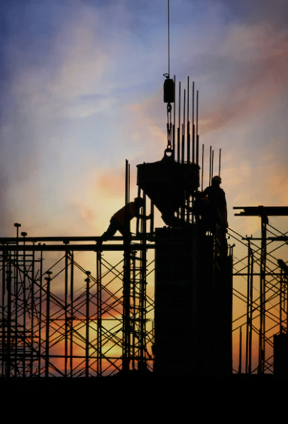 construction site with workers at sunset